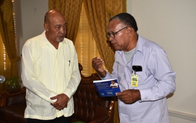 Gerrit Pollack overhandigt boek aan president Bouterse