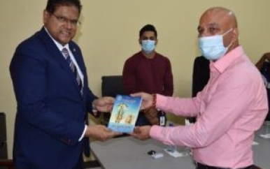 President Santokhi ontvangt heilig boek