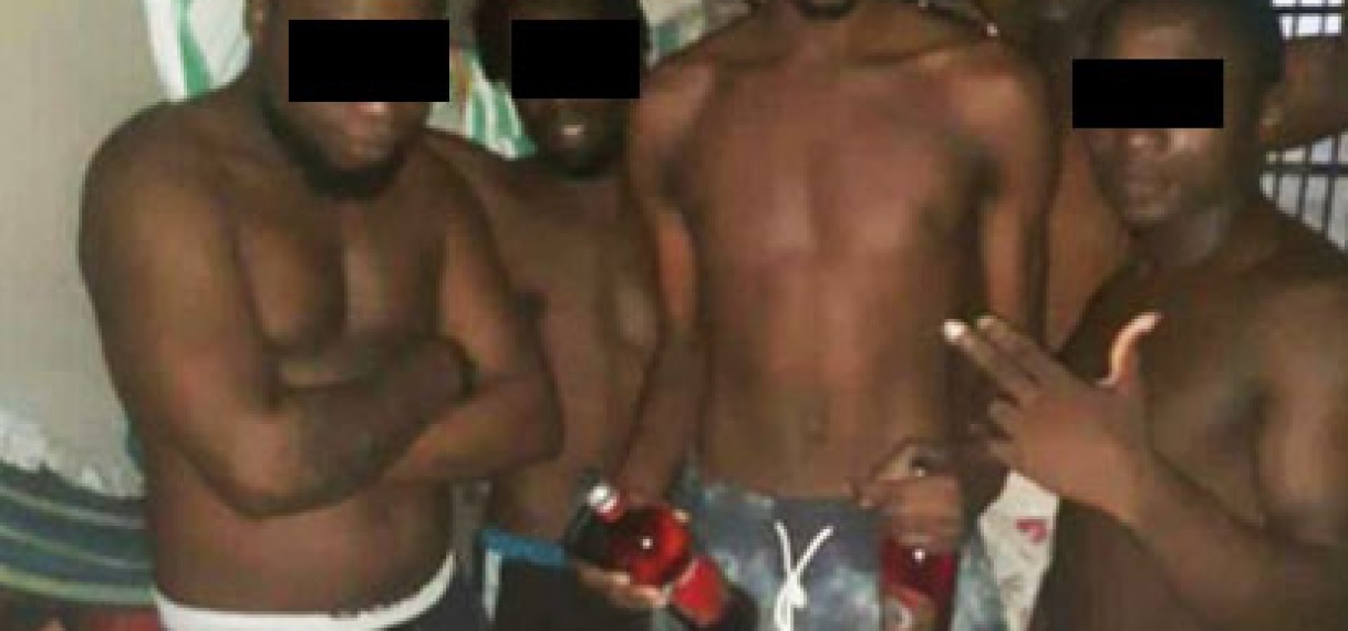 Don Gill Sneh poseert met alcohol gevulde flessen in cellenhuis