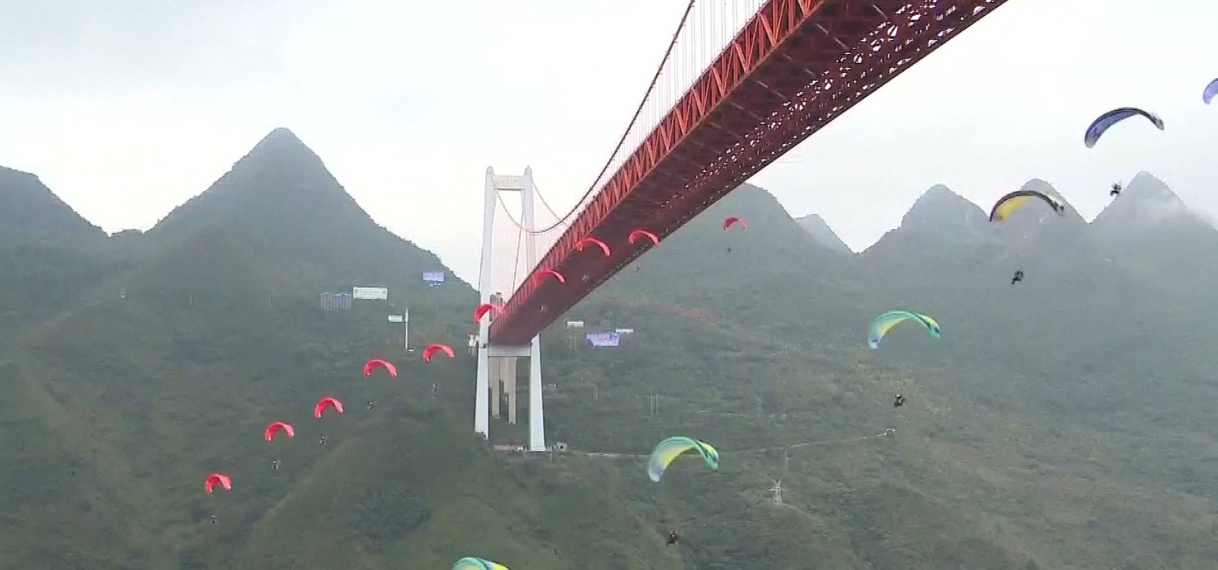 Waaghalzen springen met parachute van hoge brug in China