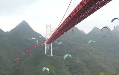 Waaghalzen springen met parachute van hoge brug in China