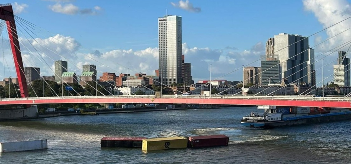 Schip ramt Willemsbrug in Rotterdam, containers in het water