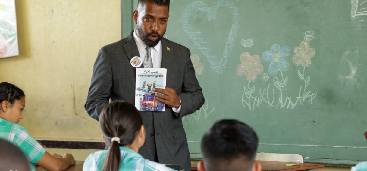 Minister Monorath leest voor aan leerlingen van O.S. Tout Lui Faut